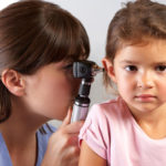 Doctor Examining Child’s Ears In Doctor’s Office